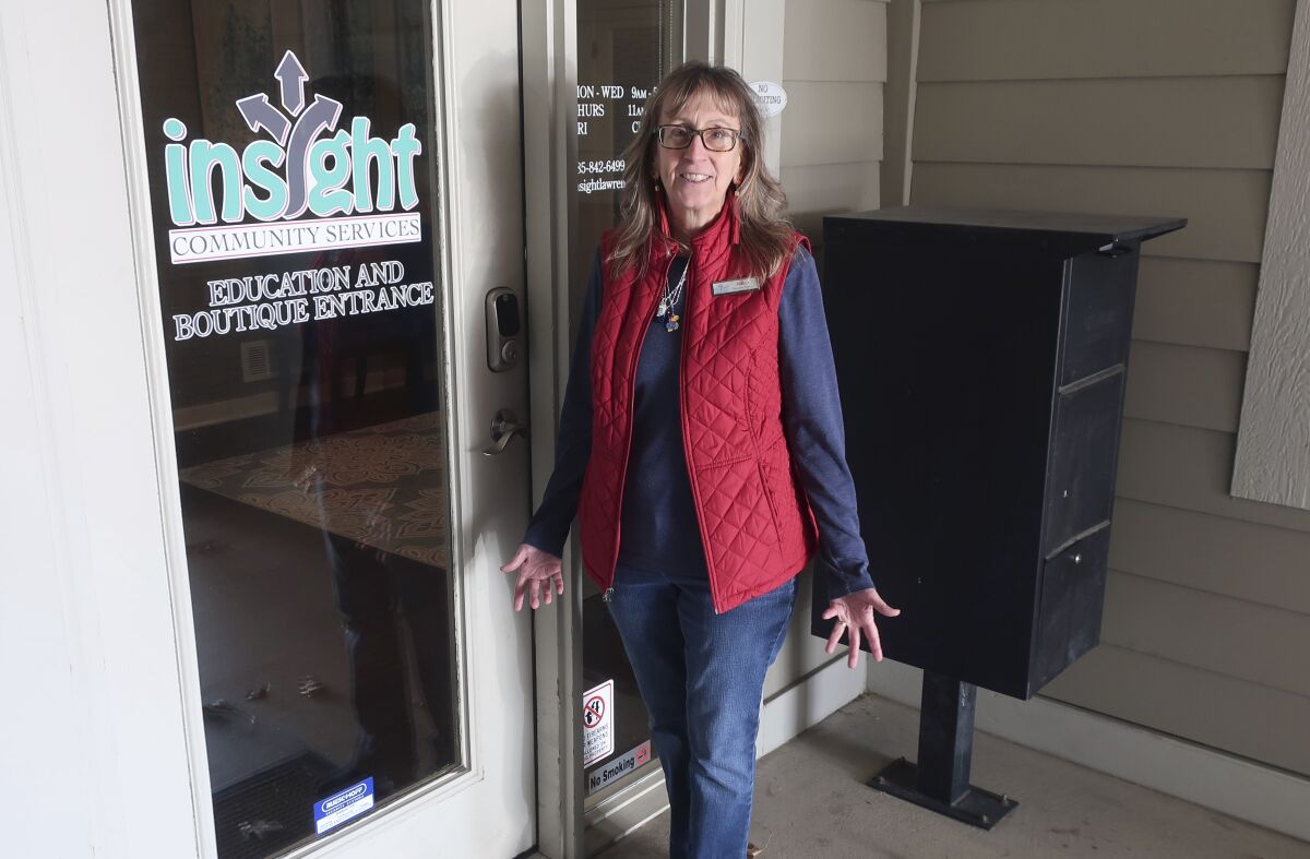 Bridgit Smith, executive director of the Insight Women's Center stands outside the door to its educational and "Boutique" with clothes and other supplies for new parents, Tuesday, Jan. 31, 2023, in Lawrence, Kansas. The center provides a variety of free services, including pregnancy tests, limited sonograms, and parenting and money-management counseling. (AP Photo/John Hanna)