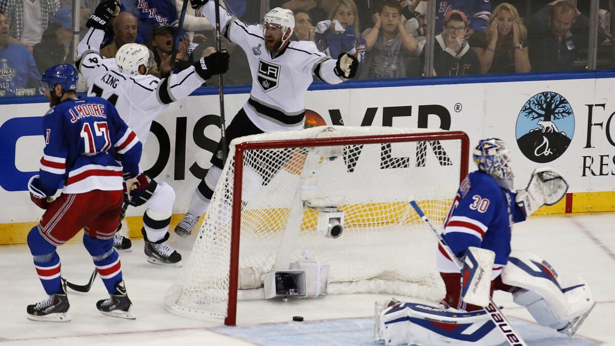 Kings forward Jeff Carter, top center, celebrates with teammate Dwight King after scoring on New York Rangers goalie Henrik Lundqvist with less than a second left in the first period of the Kings' 3-0 win in Game 3 of the Stanley Cup Final on Monday.