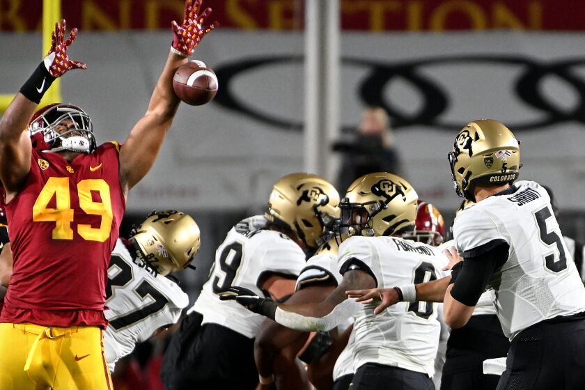 Los Angeles, California November 11, 2022- USC defensive lineman Tuli Tuipulotu knocks down a pass bay Colorado quarterback J.T. Shrout in the first quarter at the Coliseum Friday. (Wally Skalij/Los Angeles Times)