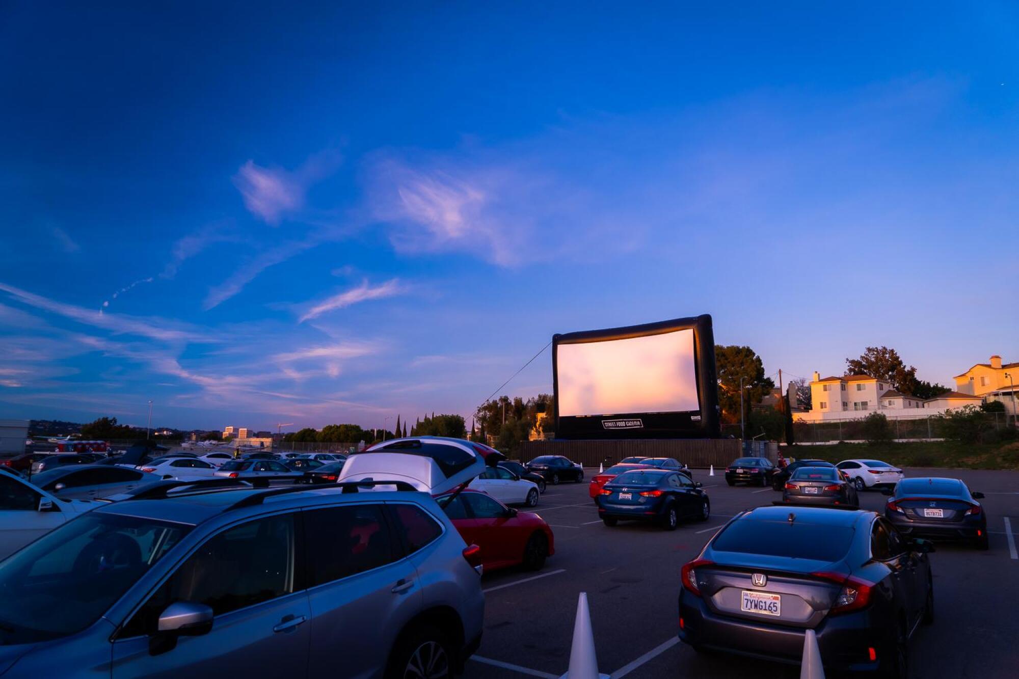 Movie screen and cars at Street Food Cinema Drive-In