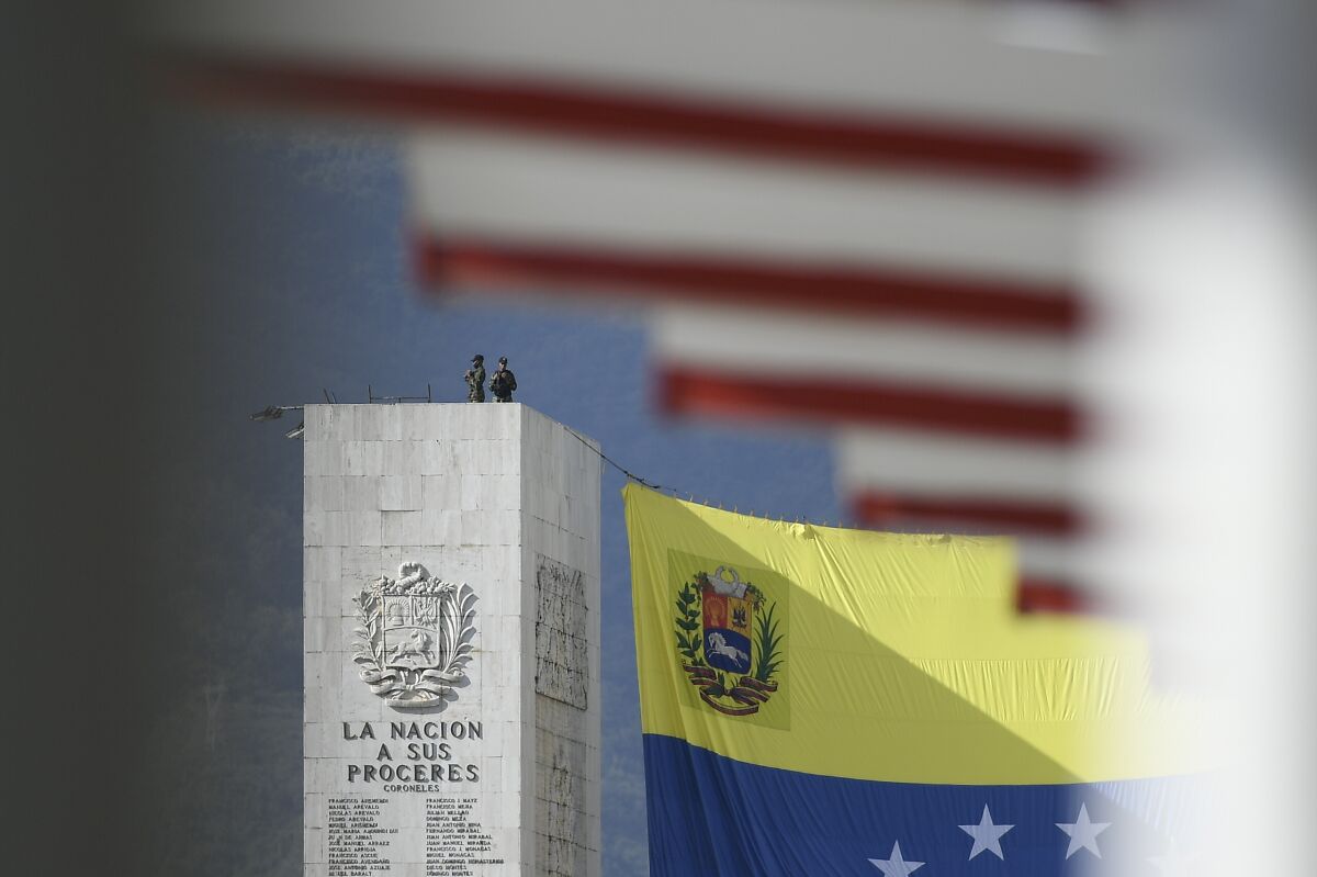 Security personnel stand watch on the monument to the heroes of the nation, prior a military parade marking Independence Day in Caracas, Venezuela, Monday, July 5, 2021. Venezuela is marking 210 years of its declaration of independence from Spain. (AP Photo/Matias Delacroix)