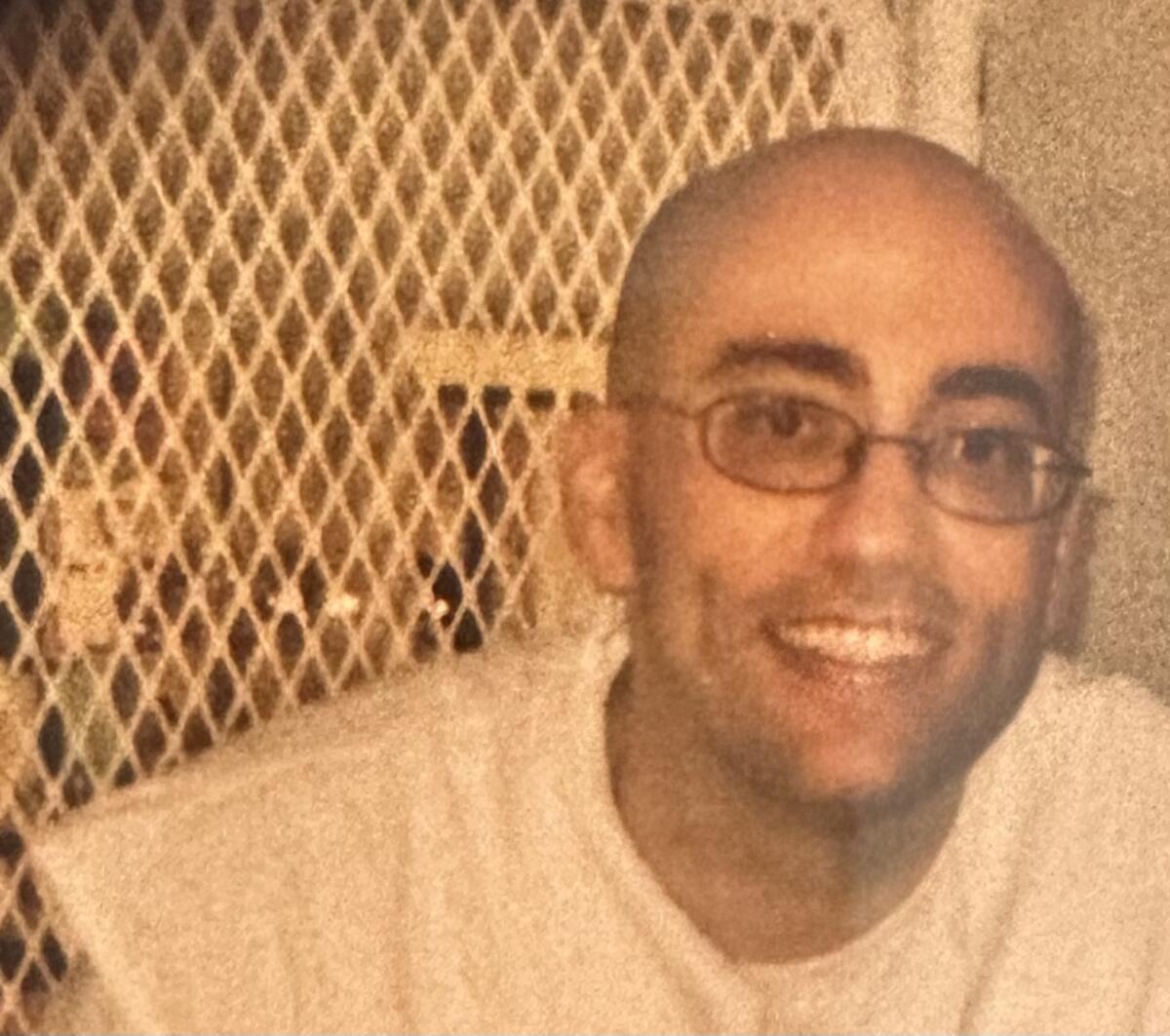 Smiling man against metal grate