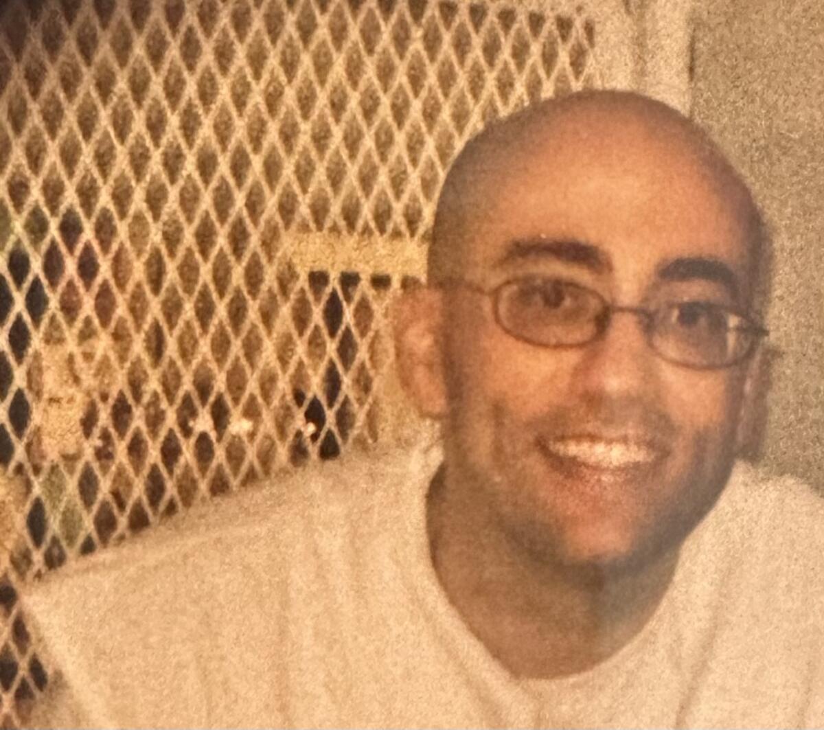 Smiling man against metal grate 