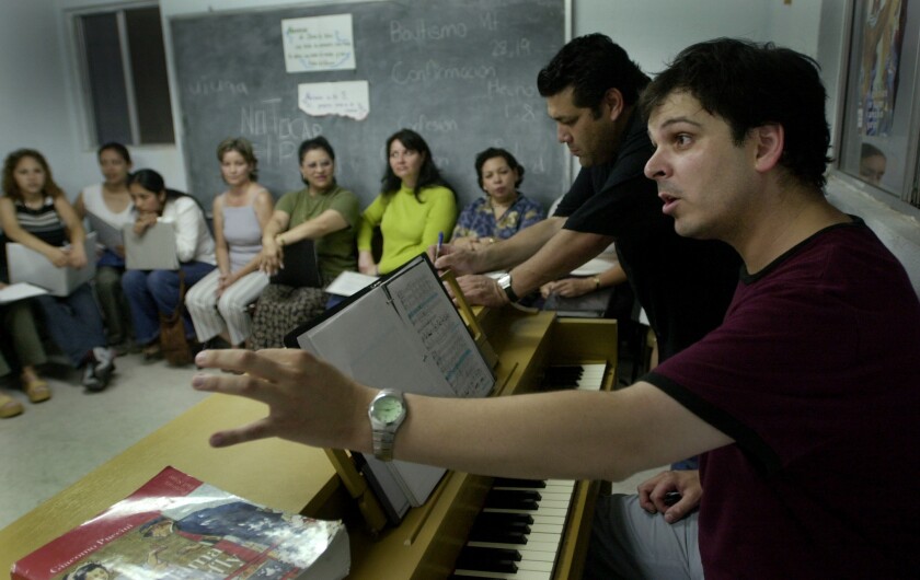 Pianist Armando Pesqueira leads the chorus in rehearsal at a church 
