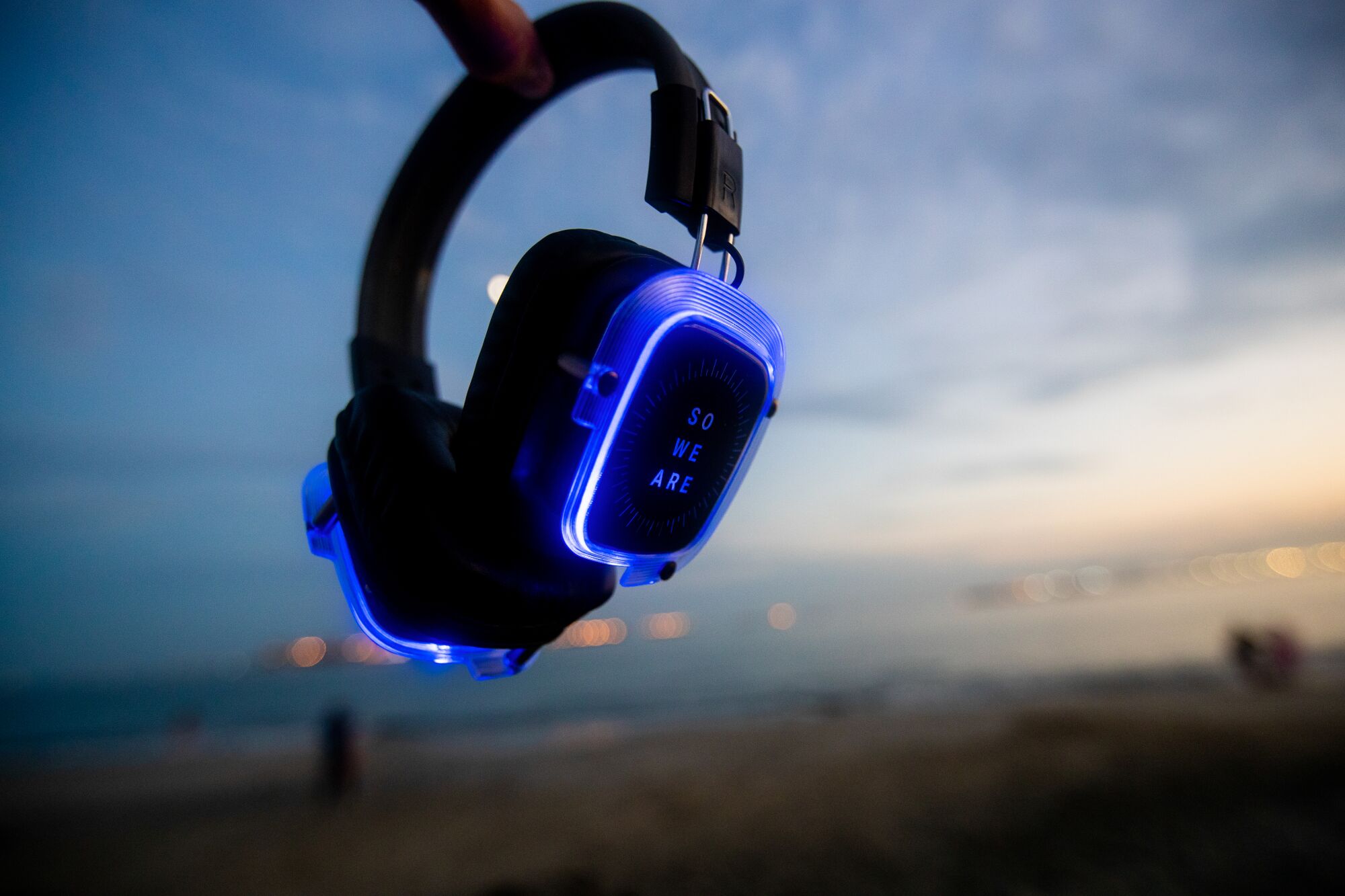 A detail image of headphones used for silent disco dances, inscribed with the words, "So We Are."