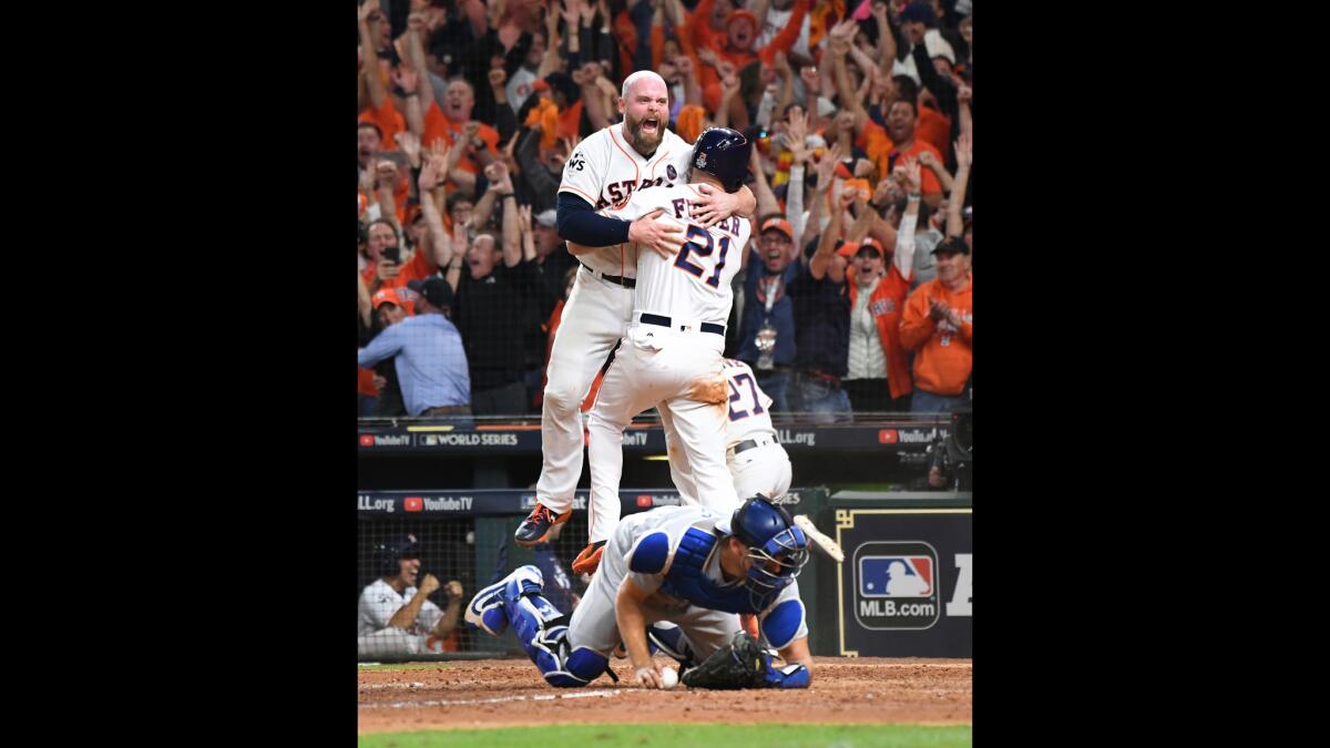 Astros Brian McCann celebrates with pinch riunner Derek Fisher to beat the Dodgers in Game 5 of the World Series at Minute Maid Park in Houston.