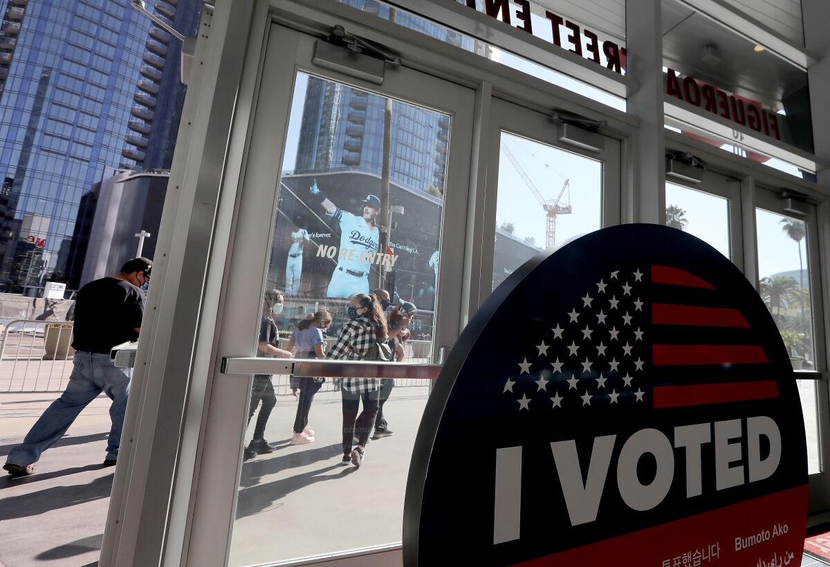 Voters leave Staples Center after casting their ballots on Friday.