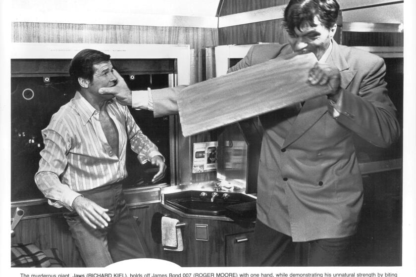 Roger Moore fights with Richard Kiel, as Jaws, who bites through a board in a scene from the film 'The Spy Who Loved Me' (1977).