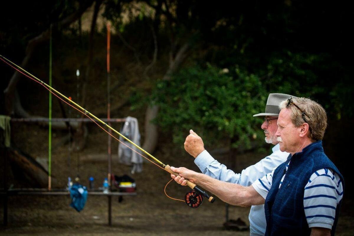 Chris Erskine, right, takes a fly-fishing lesson from Eric Callow at the Pasadena Casting Club.