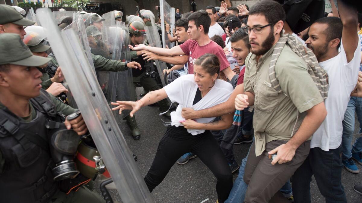 Venezuelan opposition activists scuffle with national guard personnel in riot gear during a protest in front of the Supreme Court in Caracas on Friday.