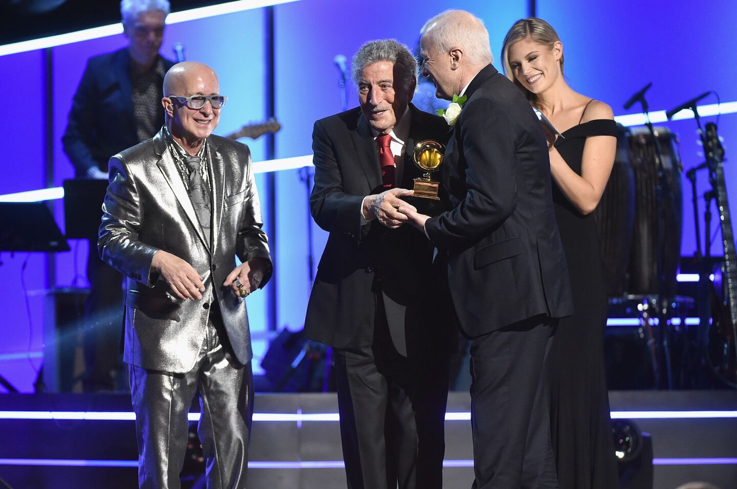 Paul Shaffer, left, presents the award for traditional pop vocal album to recording artist Tony Bennett, center, and audio engineer Dae Bennett for "Tony Bennett Celebrates 90," at the pre-telecast show Sunday.