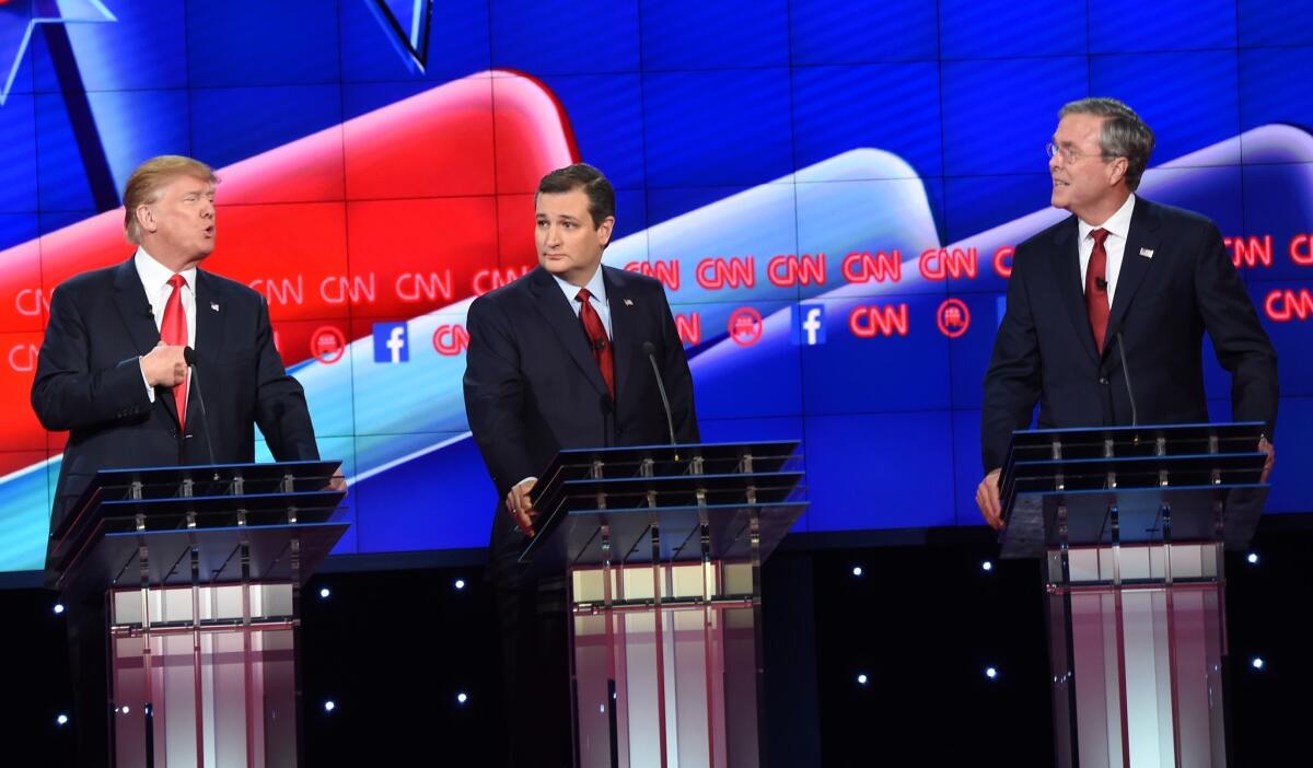 Republican presidential candidate former Florida Gov. Jeb Bush (R) and businessman Donald Trump (L) speak as Texas Sen. Ted Cruz (C) looks on during the Republican Presidential Debate, hosted by CNN, at The Venetian Las Vegas on December 15, 2015 in Las Vegas, Nevada. AFP PHOTO/ ROBYN BECKROBYN BECK/AFP/Getty Images ** OUTS - ELSENT, FPG, CM - OUTS * NM, PH, VA if sourced by CT, LA or MoD **
