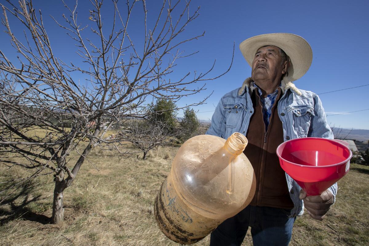 Francisco Ramirez Cruz with an empty water collector on his family's ranch in Ejido La Mesa, Mexico. Climate change has meant the wet season is shorter and more brutal than in previous years, with a drier season that is even more dry.