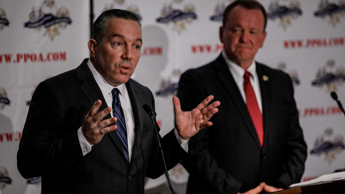 Retired Sheriff's Lt. Alex Villanueva, left, debates L.A. County Sheriff Jim McDonnell at a July event hosted by the Professional Peace Officers Assn.