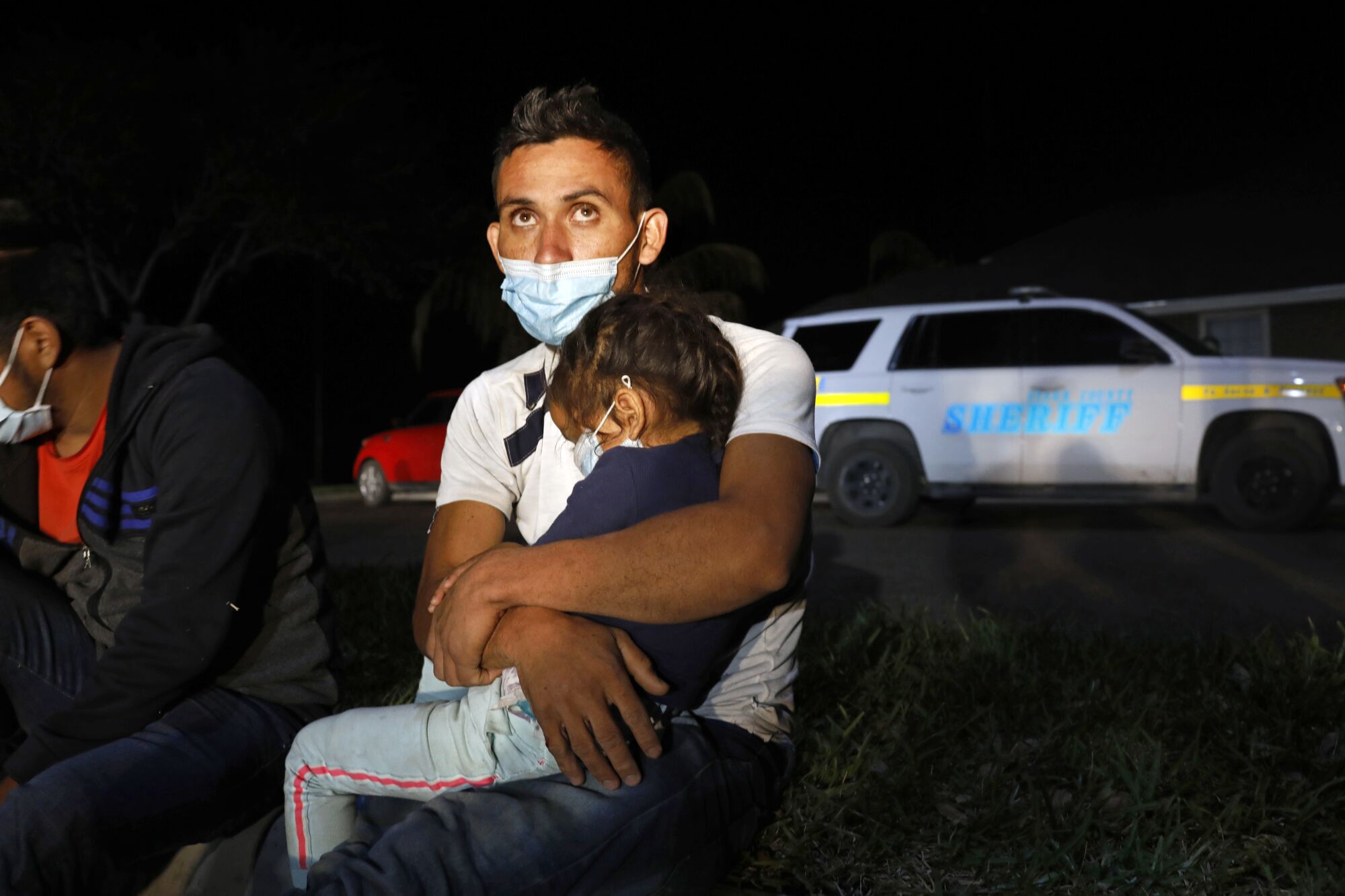 A man sits with a child in his lap.