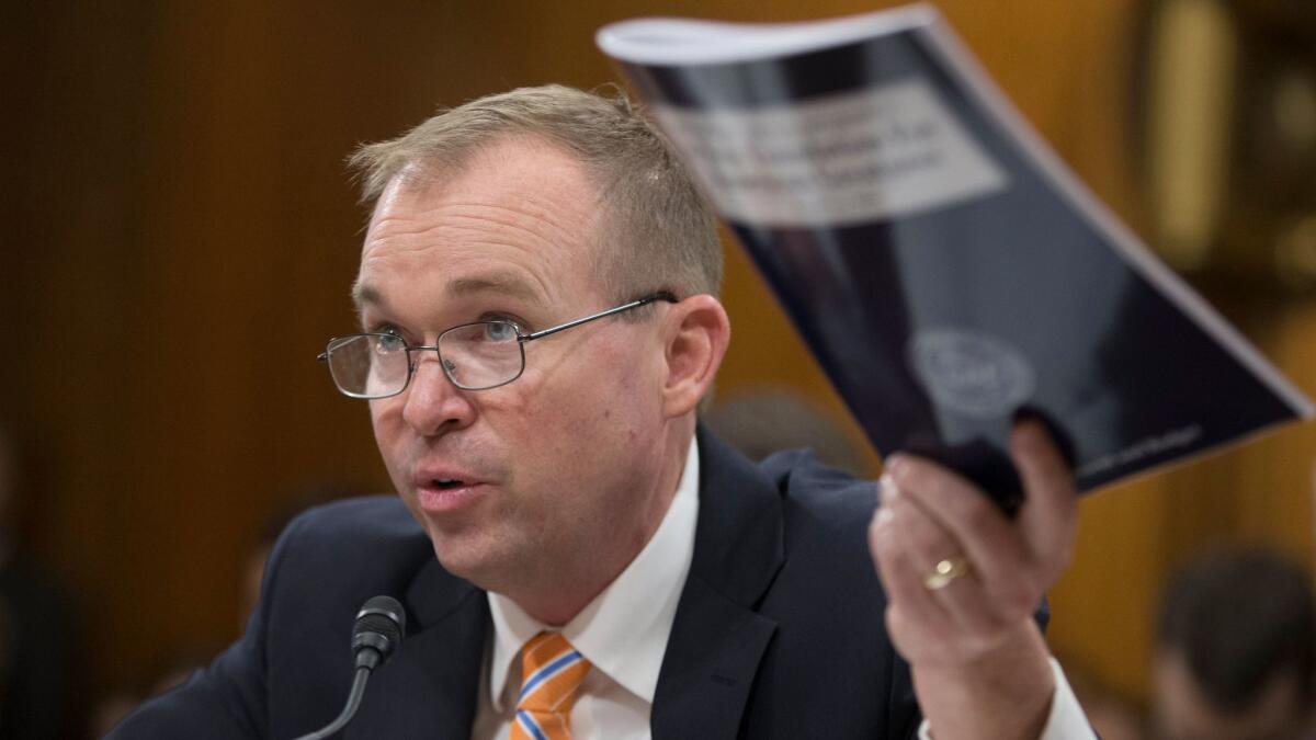 Office of Management and Budget (OMB) Director Mick Mulvaney holds a copy of the President's budget proposal while testifying during the Senate Budget Committee hearing in Capitol Hill on May 25.