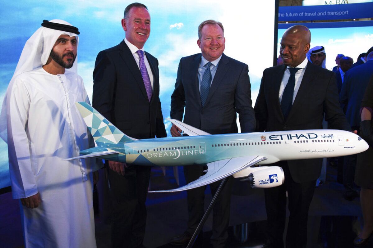 Etihad CEO Tony Douglas, second from left, helps present a model of the Boeing 787 Dreamliner at the Dubai Airshow in Dubai, United Arab Emirates, on Monday. Douglas is joined by Etihad COO Mohammad al-Bulooki, far left, and Boeing executives.