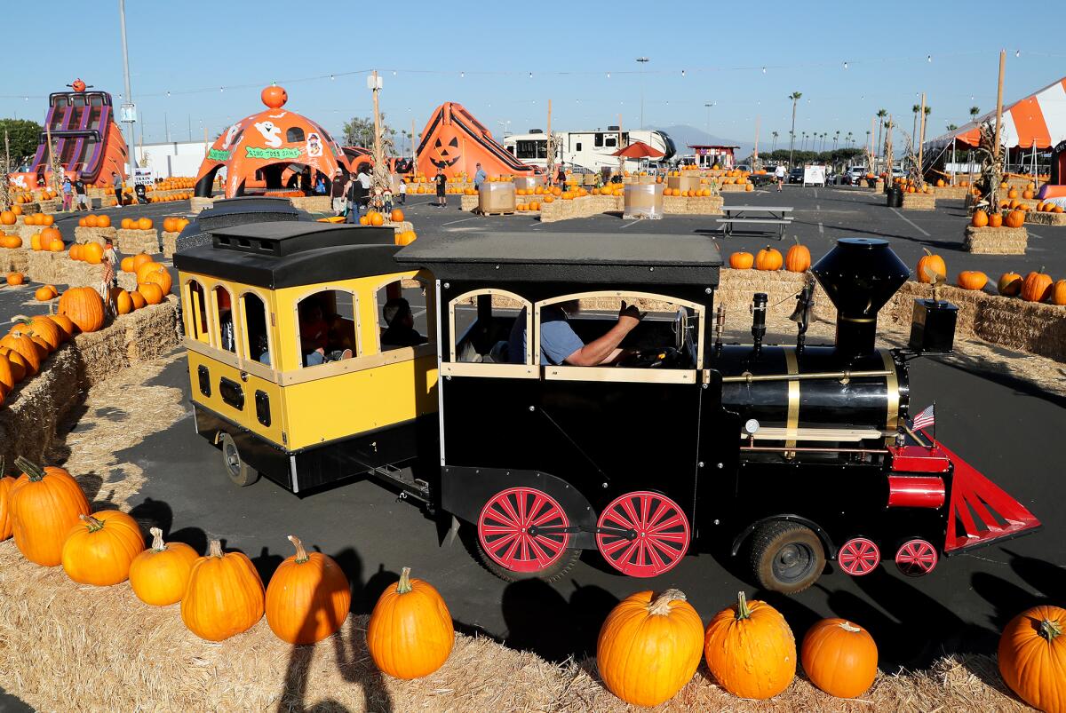 Visitors take a train ride during Seasonal Adventures on Friday at the O.C. fairgrounds in Costa Mesa.