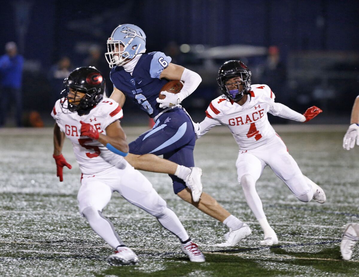 Corona del Mar's John Humphreys runs after the catch against Grace Brethren's George Bowers IV (4) and Julien Stokes in the CIF Southern Section Division 3 title game on Friday at Newport Harbor High.