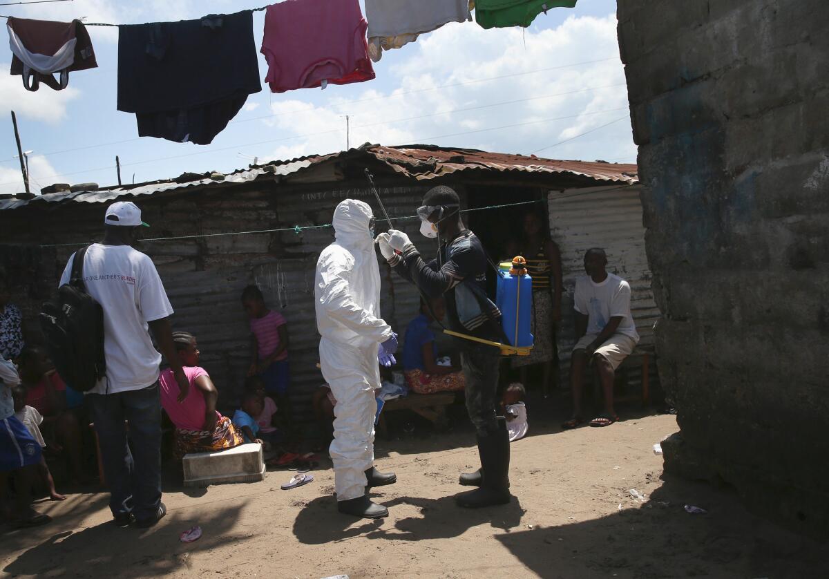 Health workers on Friday suit up in protective clothing in Monrovia, Liberia, before taking people suspected of having Ebola to a reopened Ebola holding center.