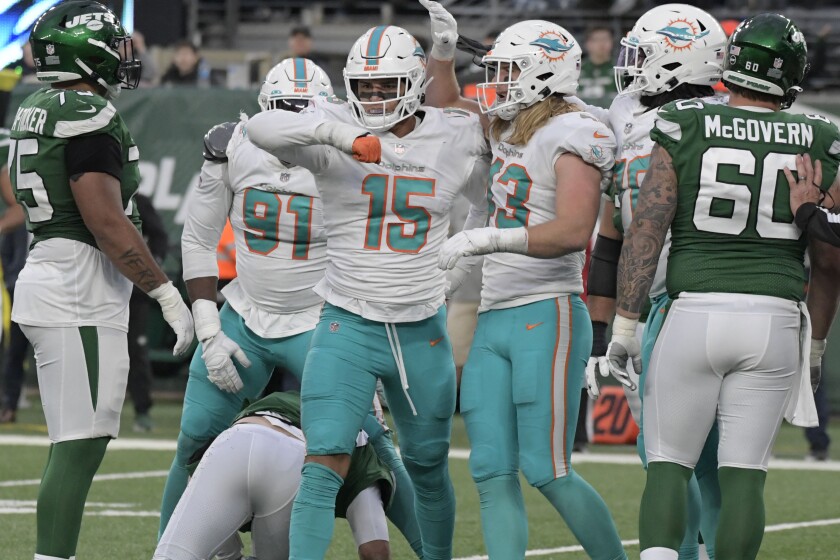 Miami Dolphins' Jaelan Phillips (15), center, celebrates his sack of New York Jets quarterback Joe Flacco during the second half of an NFL football game, Sunday, Nov. 21, 2021, in East Rutherford, N.J. (AP Photo/Bill Kostroun)