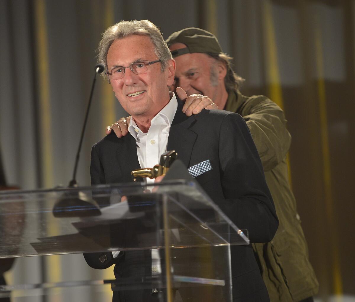 Al Schmitt, with Neil Young, accepts the Pensado Giant Award in 2014.