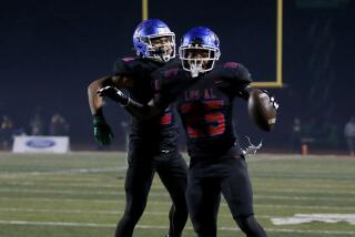 Los Alamitos running back Anthony League (25) celebrates with teammate Gavin Porch after scoring a touchdown against LB Poly.