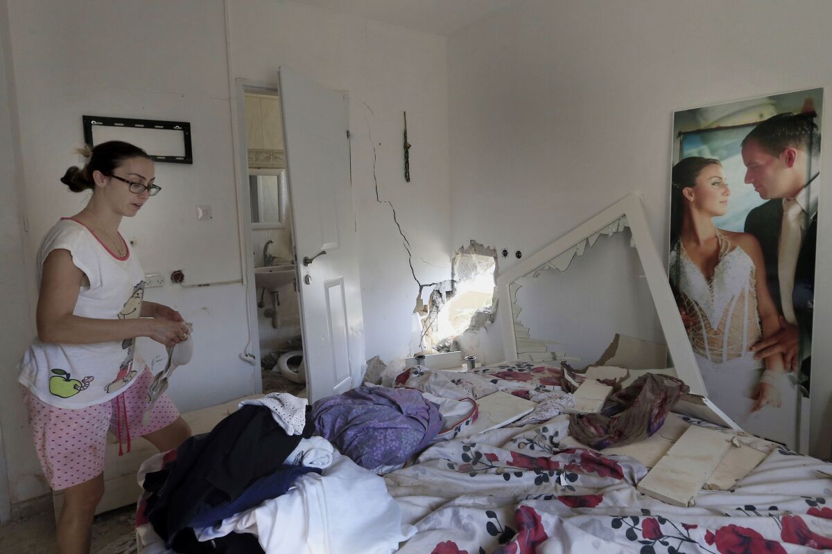 Tammy Giorno cleans up her bedroom in the southern Israeli town of Sderot after it was hit by a rocket fired by Palestinian militants in the Gaza Strip.