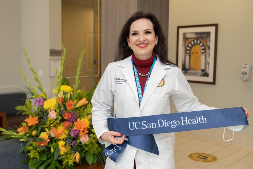 UC San Diego Headache Center and Traumatic Brain Injury facility director Nina Riggins holds the cut ribbon of the Sorrento Valley facility.