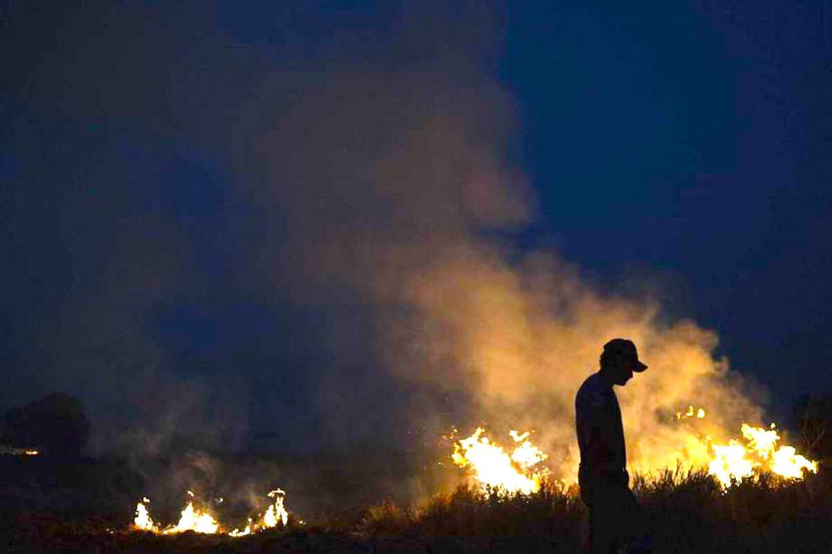 La silueta de Neri dos Santos Silva se observa junto a un incendio amenazante después de que cavó trincheras para evitar que las llamas se propaguen a la granja en la que trabaja, en el municipio de Nova Santa Helena, en el estado de Mato Grosso, Brasil.