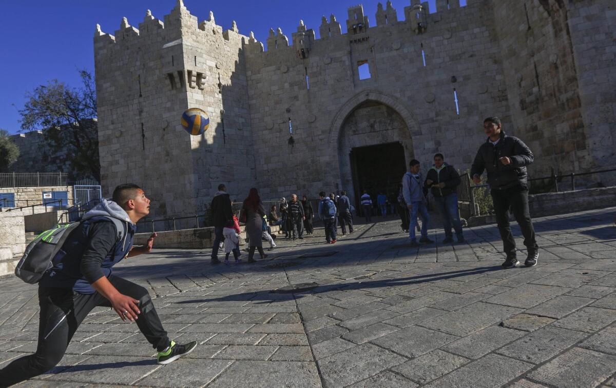 Palestinian students play with a ball in front of the landmark Damascus Gate in the Old City of Jerusalem on Dec. 9, 2015.