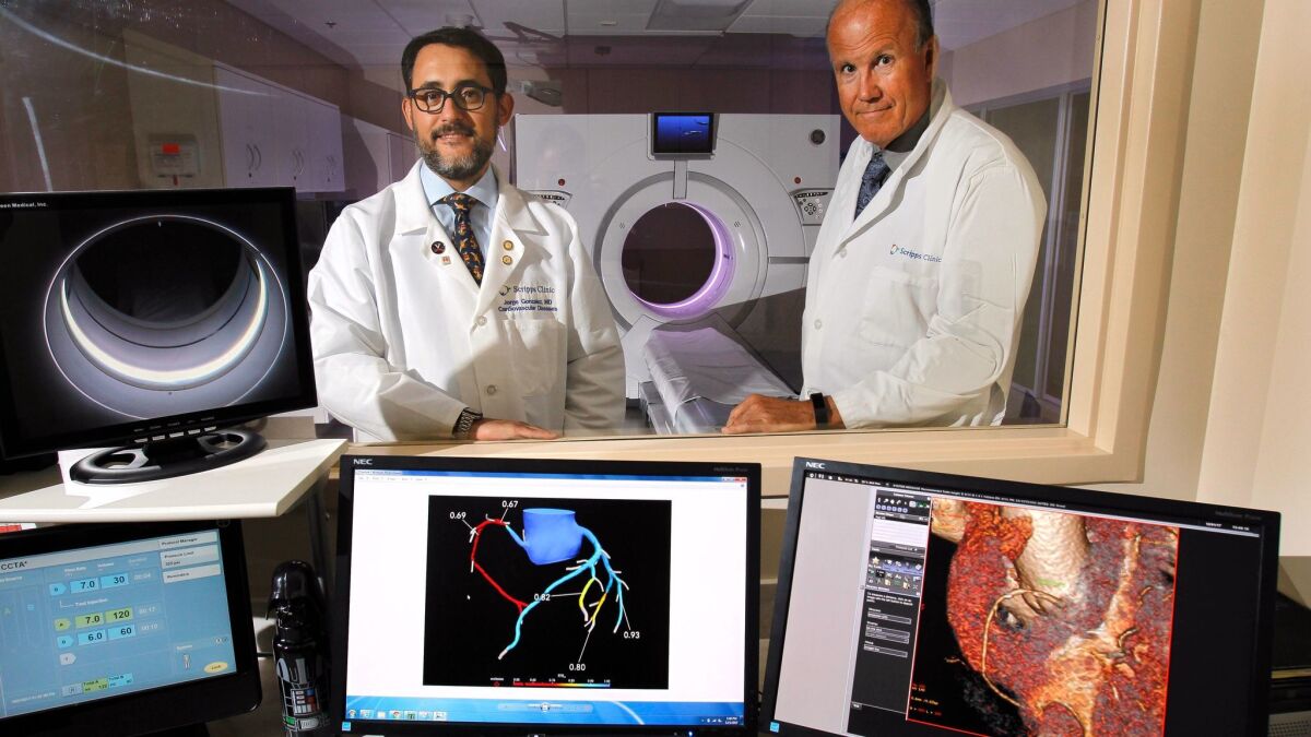 Dr. George Wesbey (right) Dr. Jorge Gonzalez stand with the digital heart models created by HeartFlow FFR, a new analytics system that uses high-resolution digital X-ray scans to model blood flow in the coronary arteries.