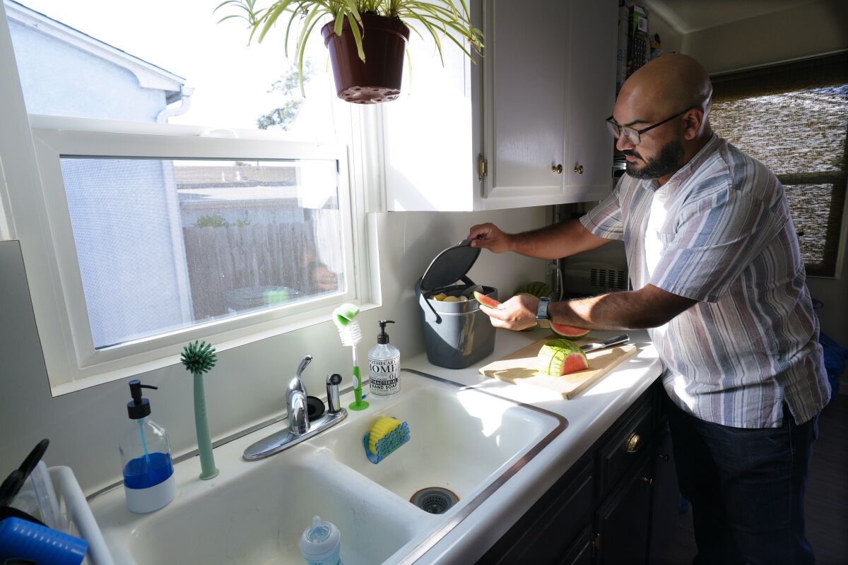 Victor Sanchez places his food waste in a special countertop food container at his home in National City on Thursday.