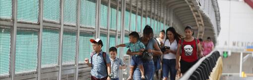 FILE - In this June 28, 2019 file photo, local residents with visas walk across the Puerta Mexico international bridge to enter the U.S., in Matamoros, Tamaulipas state, Mexico. A U.S. judge in Oregon on Tuesday, Nov. 26, 2019, granted a preliminary injunction blocking a Trump administration proclamation that would require immigrants to show proof of health insurance to get a visa. (AP Photo/Rebecca Blackwell, File)