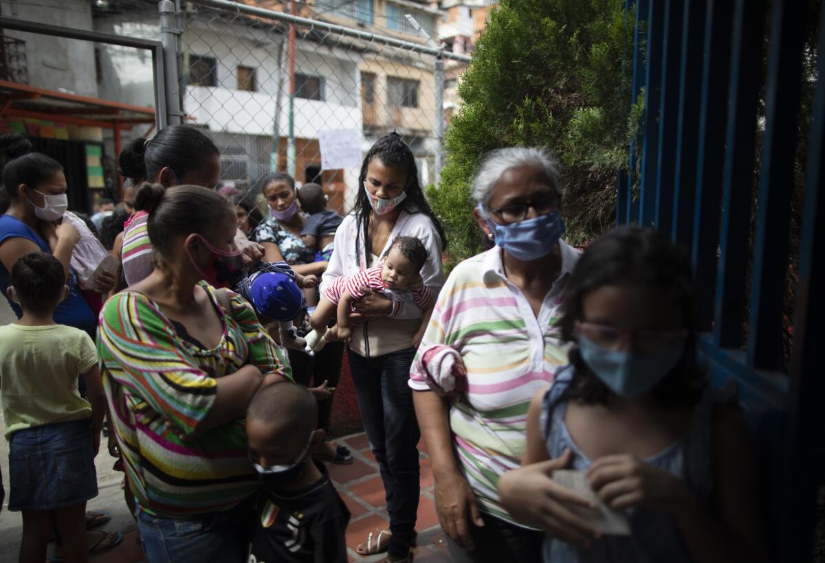 Varias mujeres y niños, con mascarillas para protegerse del coronavirus, 