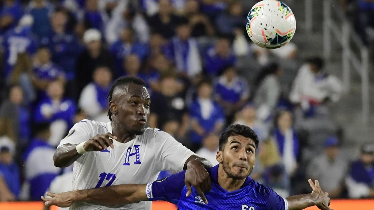 Honduras forward Alberth Elis, left, and El Salvador defender Jonathan Jimenez compete for the ball during the second half of a CONCACAF Gold Cup match on Tuesday at Banc of California Stadium.
