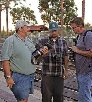 Rail enthusiasts look over pictures they've snapped at the Fullerton station. Weekends bring gatherings of the rail buffs to the station.