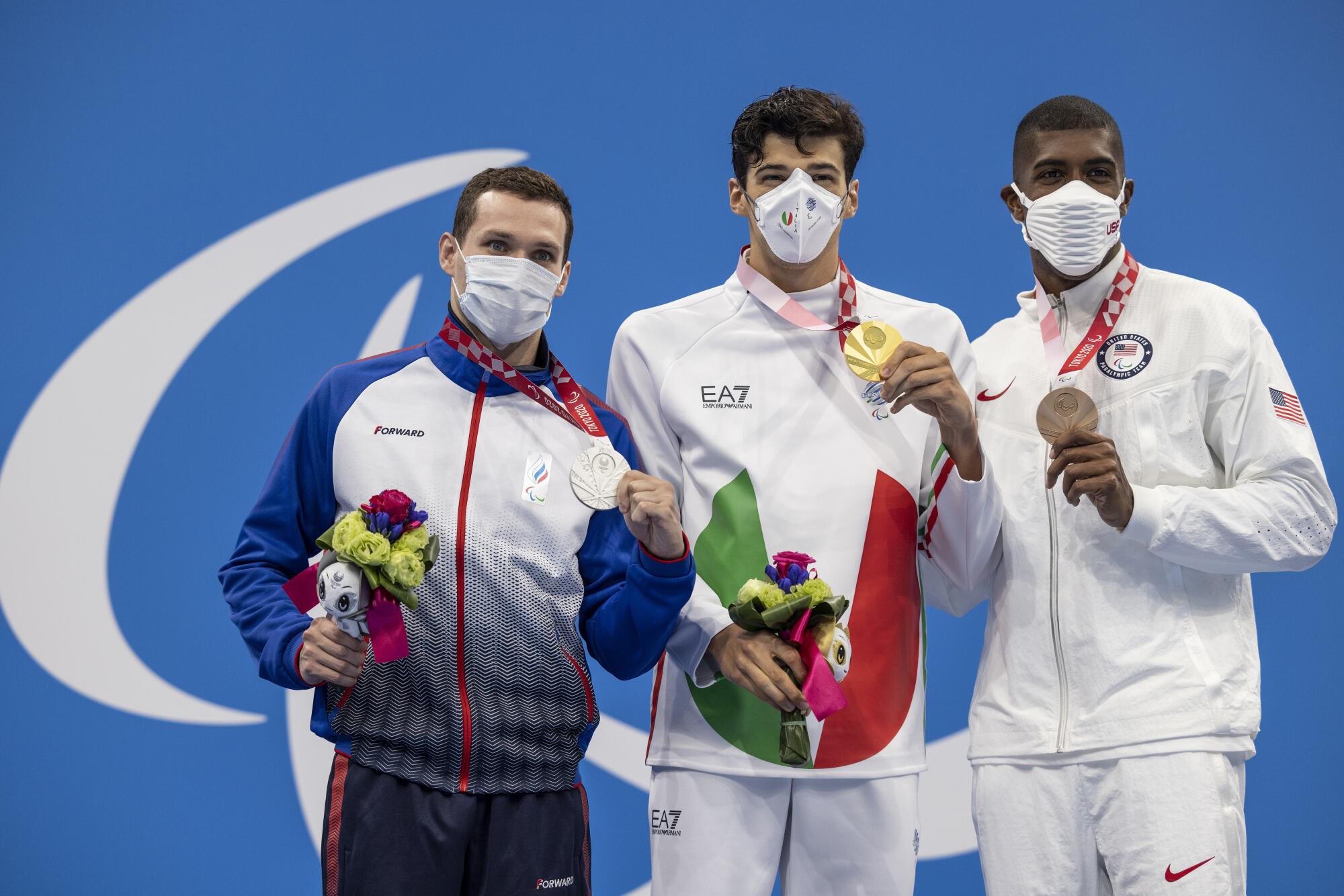 Jamal Hill, right, holds his bronze medal next to silver medalist Denis Tarasov and gold medalist Simone Barlaam