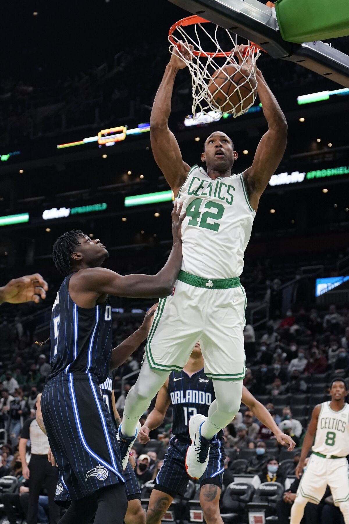 Boston Celtics center Al Horford (42) slams a dunk against Orlando Magic center Mo Bamba, left, during the first half of an NBA preseason basketball game, Monday, Oct. 4, 2021, in Boston. (AP Photo/Charles Krupa)