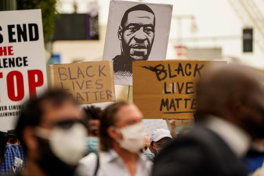 LOS ANGELES, CA - JUNE 02: A sign with the likeness of George Floyd is seen as Protesters and Clergy members from the Los Angeles area participate in a march and peaceful protest in downtown Los Angeles outside of LA City Hall and LAPD Headquarters on Tuesday, June 2, 2020 in Los Angeles, CA. Protests erupted across the country, with people outraged over the death of George Floyd, a black man killed after a white Minneapolis police officer pinned him to the ground with his knee. (Kent Nishimura / Los Angeles Times)