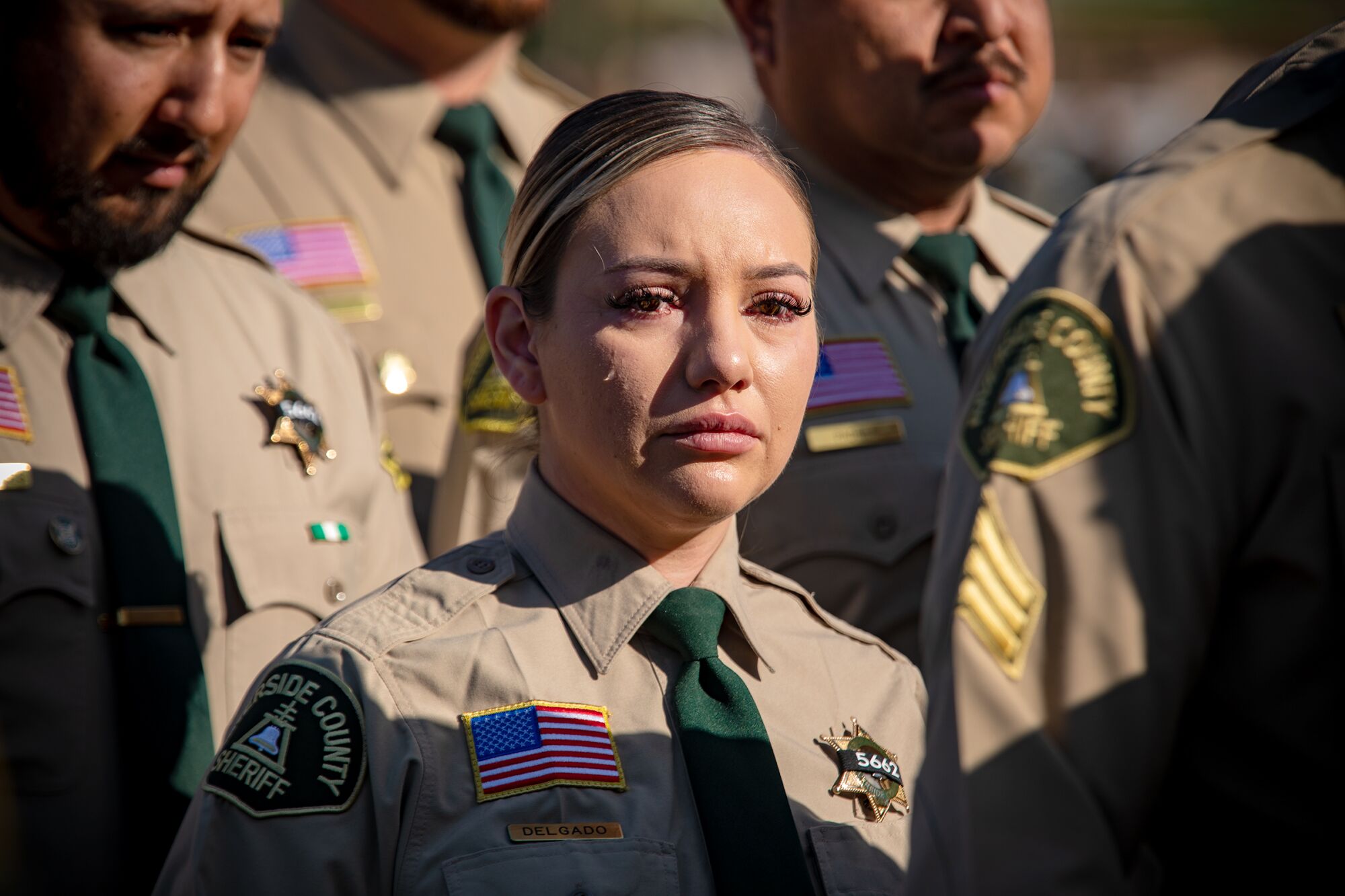 Tears roll down the cheek of a Riverside County Sheriff deputy at funeral services of her colleague, deputy Isaiah Cordero