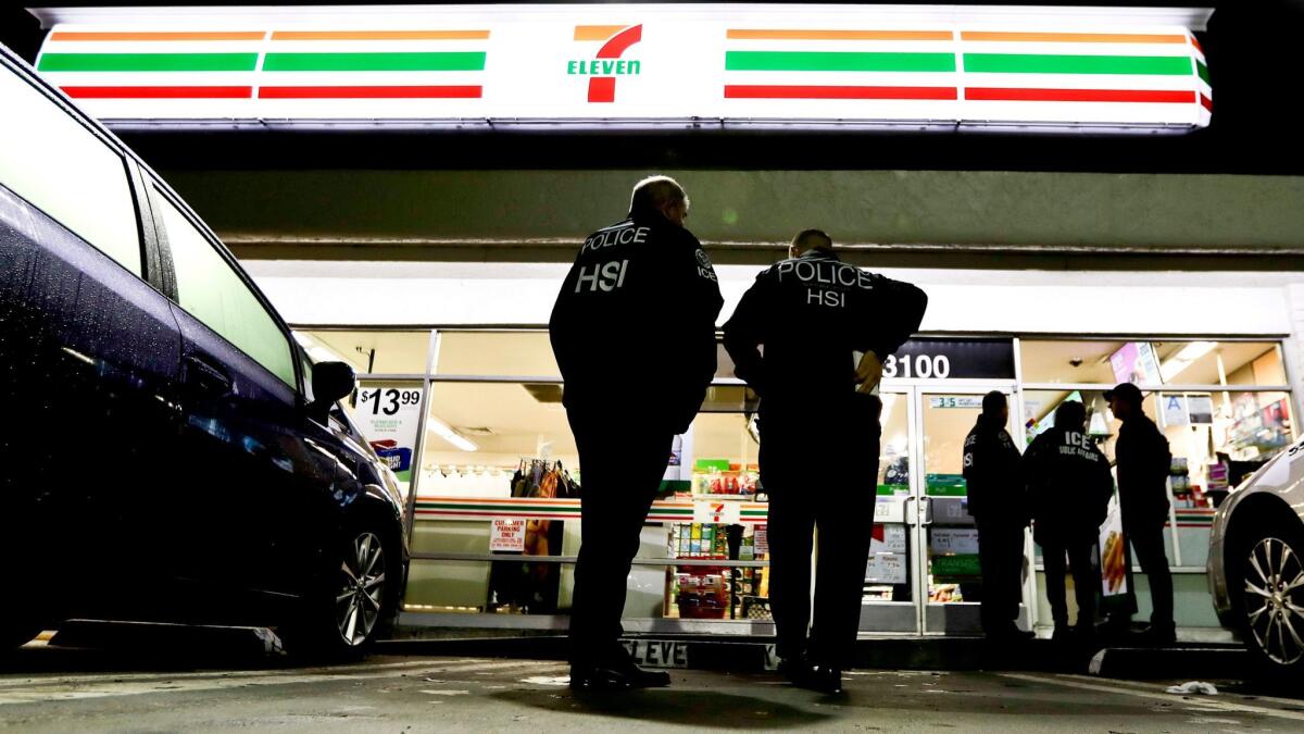 U.S. Immigration and Customs Enforcement agents serve an employment audit notice at a 7-Eleven store in Los Angeles on Jan. 10.
