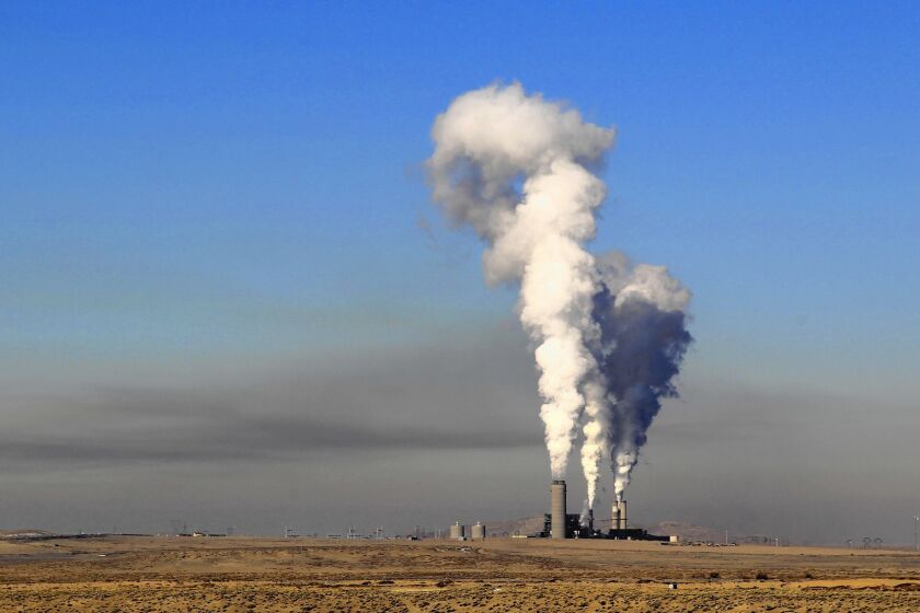 A layer of haze looms west of the Four Corners Generating Station in New Mexico. Southern California Edison recently sold its stake in the power plant, but the facility still burns coal to produce power that goes to Arizona customers instead.