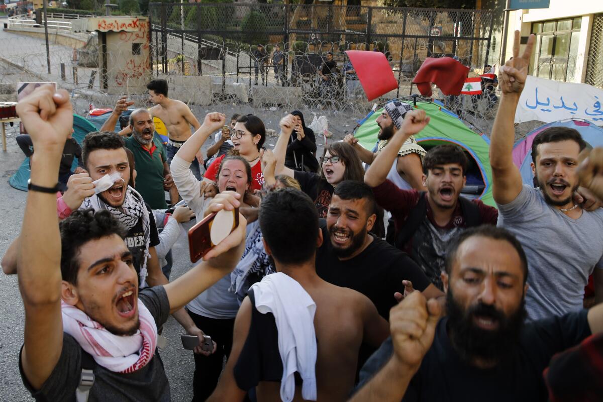 Anti-government protesters celebrate after Lebanon Prime Minister Saad Hariri announced he is submitting his resignation, meeting one of their main demands, in front of the government palace in Beirut on Oct. 29, 2019.