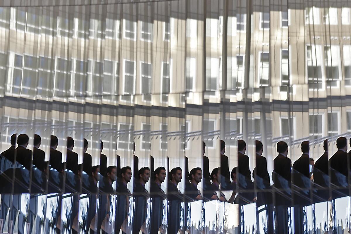 Two staff members are reflected dozens of times as they ascend a mirror-lined spiral staircase in the lobby of the W Hotel in Hollywood on Jan. 26, 2010. The hotel is LEED-certified by the U.S. Green Building Council.