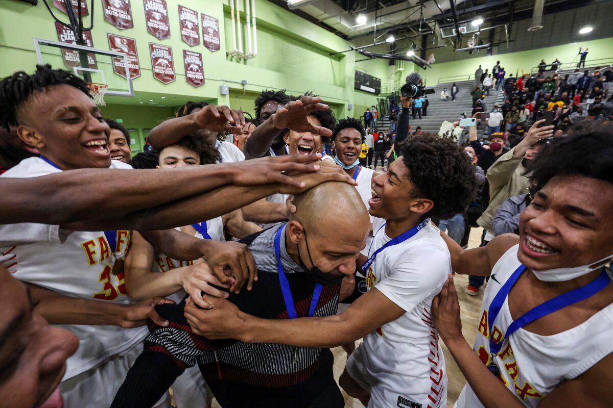 Fairfax High players celebrate with coach Reggie Morris Jr. after beating King/Drew for the City Section Open Division title.