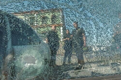 A group of experts inspect a vehicle after an armed assault in Tijuana.