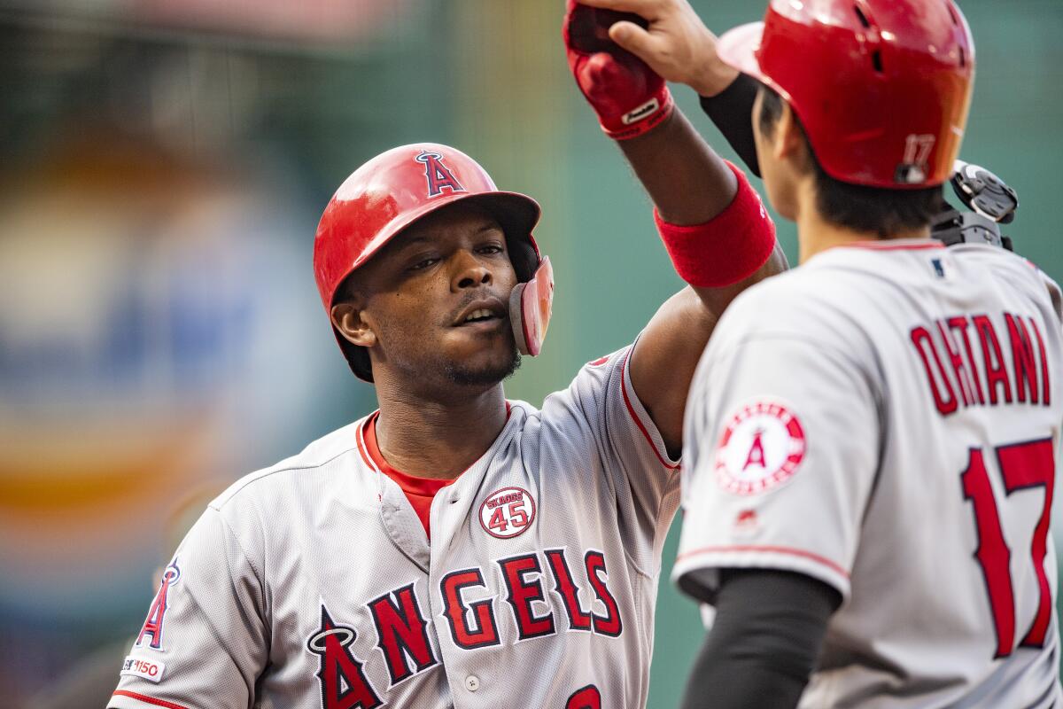 Justin Upton high-fives Angels teammate Shohei Ohtani after hitting a three-run home run against the Boston Red Sox on Aug. 10 at Fenway Park.