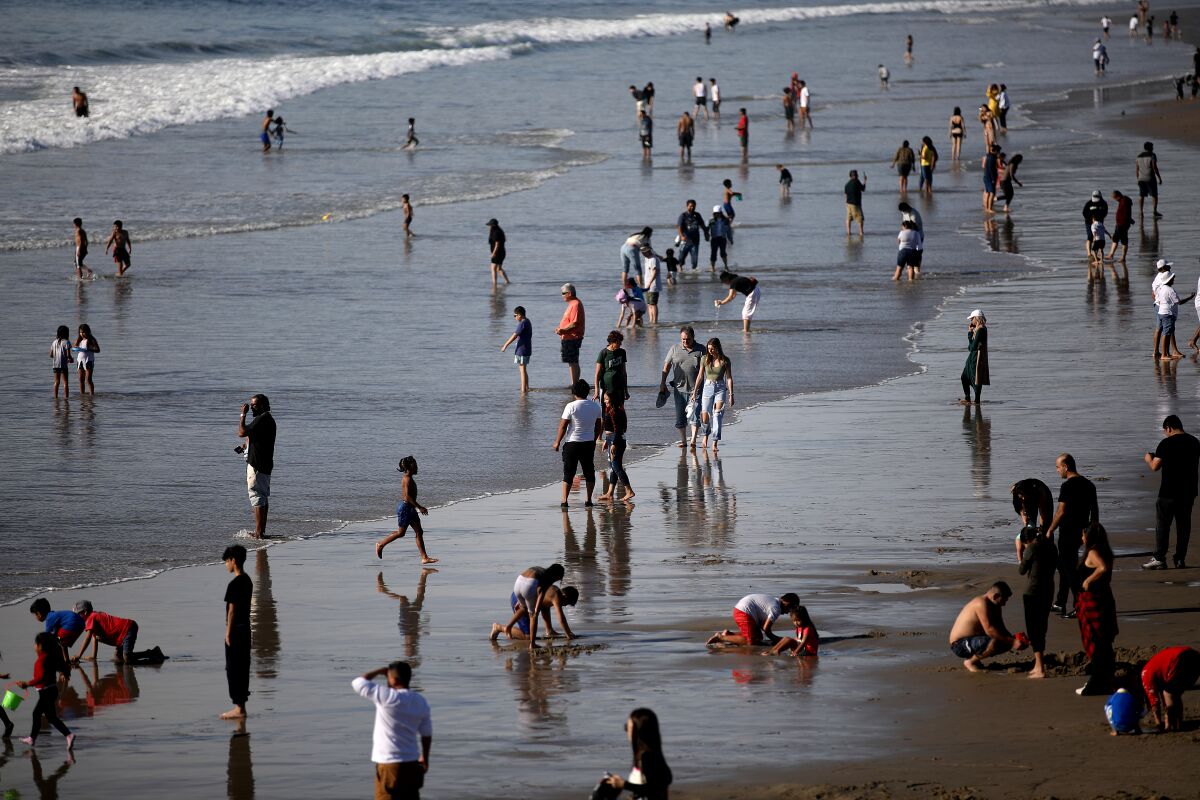 Orang-orang di sepanjang pantai di pantai Santa Monica pada Hari Natal.