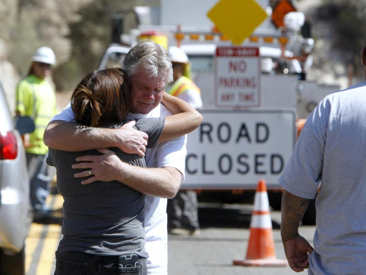 Mari Tovar, Samantha Ornelas' aunt, is hugged by the father of Kasey Vance, who did not want to give his name, as they arrive to find gates closing off Angeles Crest Highway near where the bodies of three people were being recovered Tuesday. (Raul Roa / La Caada Valley Sun)